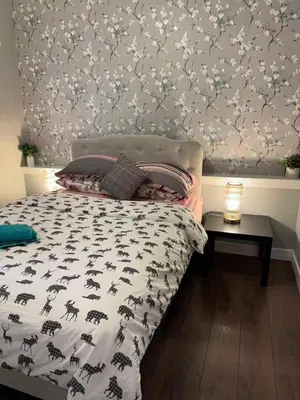 a bedroom with a bed with a floral wallpaper at Lovely 2 bedroom suite in Langford in Metchosin