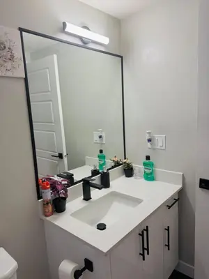 a bathroom with a sink and a large mirror at Roj exclusive comfort home in Edmonton