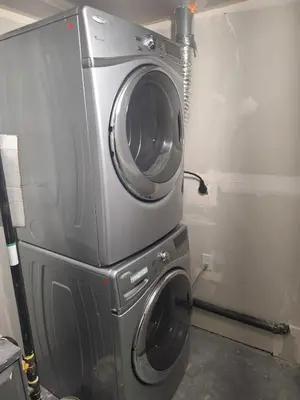 a washing machine sitting on top of a washer at Roj exclusive comfort home in Edmonton