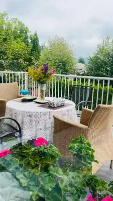 a table with a vase of flowers on a patio at Warm house1 in Coquitlam