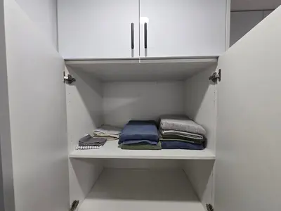 a walk in closet with white cabinets and towels at Clearwater Chestermere in Chestermere