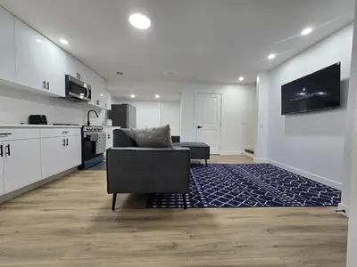 a living room with a couch and a kitchen at Clearwater Chestermere in Chestermere
