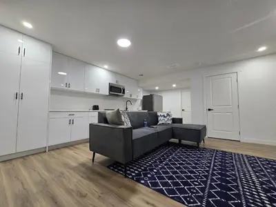 a living room with a couch and a kitchen at Clearwater Chestermere in Chestermere