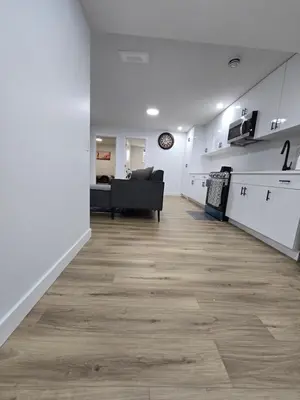 a living room with a couch and a kitchen at Clearwater Chestermere in Chestermere