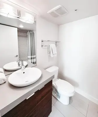 a white bathroom with a sink and a toilet at Riverside Mint 2bd den 2 ba in Calgary