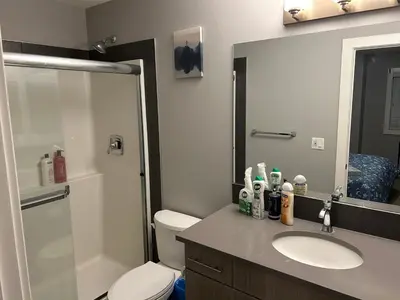 a bathroom with a sink and a toilet and a mirror at Family friendly home at Chappelle garden in Edmonton