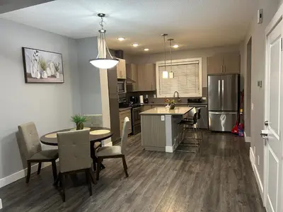 a kitchen and dining room with a table and chairs at Family friendly home at Chappelle garden in Edmonton