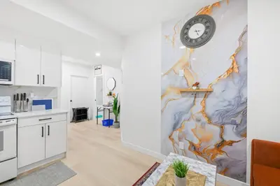 a kitchen and living room with a clock on the wall at Laurel 27BnB in Edmonton
