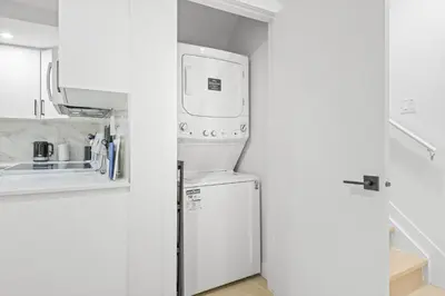 a small kitchen with a refrigerator and a sink at Laurel 27BnB in Edmonton