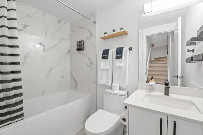 a white bathroom with a toilet and a sink at Laurel 27BnB in Edmonton