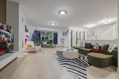 a living room with a christmas tree and a couch at Board Games, King Bed, Cocoa Bar, & Firewood! in Calgary