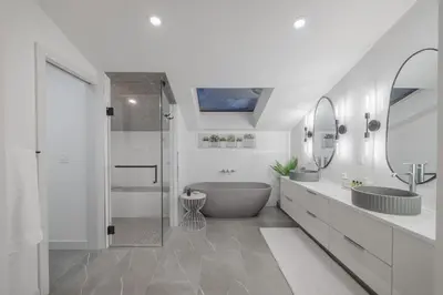 a white bathroom with a tub and a sink at Board Games, King Bed, Cocoa Bar, & Firewood! in Calgary