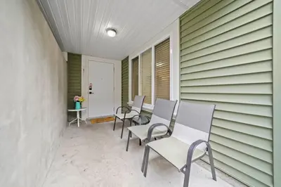 a row of chairs sitting on a porch at 2 bed Suburban Oasis in Surrey in Surrey