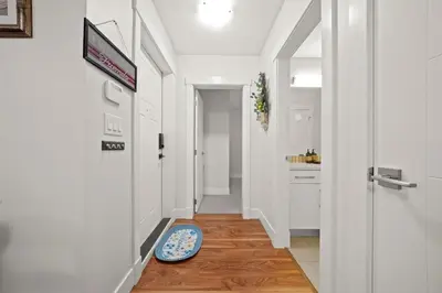 a hallway with white walls and a blue rug on the floor at 2 bed Suburban Oasis in Surrey in Surrey