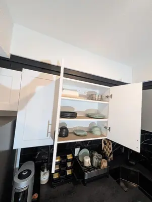 an open cabinet with plates and dishes in it at The Loft Modern in Calgary