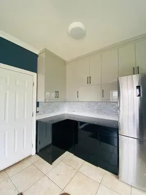 a kitchen with white cabinets and a refrigerator at 5 Minutes away from Edmonds Station! Ideal location for all events & attractions in New Westminster