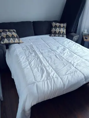 a large white bed with two pillows on a couch at Executive Suite 2 Bedroom Serviced Apartment in Alert Bay