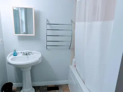 a white bathroom with a sink and a shower at Executive Suite 2 Bedroom Serviced Apartment in Alert Bay