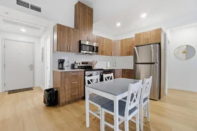 a kitchen with a table and a refrigerator at Luxury 1Beds and 2Beds in Downtown Edmonton close to Rogers in Edmonton