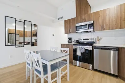 a kitchen with wooden cabinets and a table and chairs at Luxury 1Beds and 2Beds in Downtown Edmonton close to Rogers in Edmonton