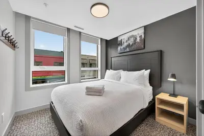 a bedroom with a large bed and two windows at Downtown Revelstoke Retreat by Canadian Rockies Vacation Rentals in Revelstoke
