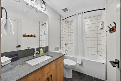 a bathroom with a sink and a toilet and a tub at Downtown Revelstoke Retreat by Canadian Rockies Vacation Rentals in Revelstoke
