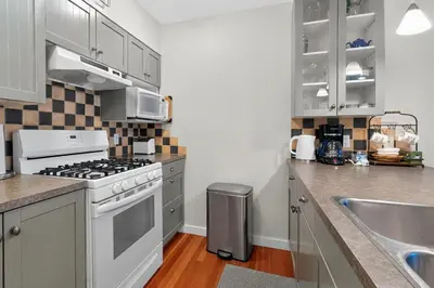 a kitchen with a stove top oven next to a sink at The Landing- Your Downtown Waterfront Oasis in Tofino