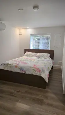 a bedroom with a bed with a floral comforter at Family Home in North Vancouver