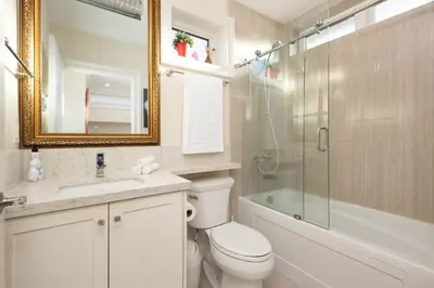 a bathroom with a toilet and a glass shower at New Quiet Charming 1BR Suite near UBC & PW Park in Vancouver