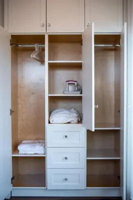 a white closet with white drawers and shelves at New Quiet Charming 1BR Suite near UBC & PW Park in Vancouver