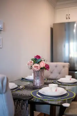 a table with a vase with flowers on it at New Quiet Charming 1BR Suite near UBC & PW Park in Vancouver