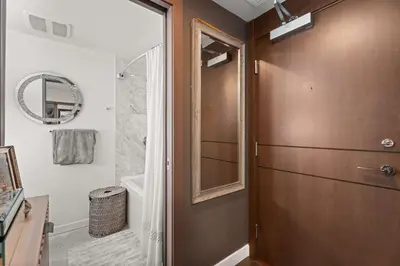 a bathroom with a shower and a glass door at Modern Chic Apartment with Balcony & Workspace in Vancouver