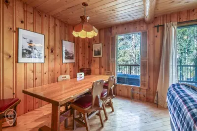a dining room with a wooden table and chairs at Pet-Friendly Original Ski Cabin by StayIn in Panorama
