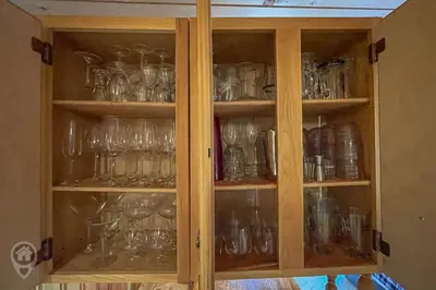 a wooden cabinet filled with glassware at Pet-Friendly Original Ski Cabin by StayIn in Panorama