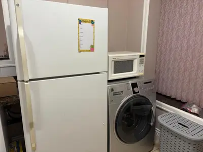 a white refrigerator in a kitchen with a washing machine at Vacation Home in Vancouver
