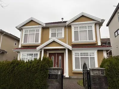 a yellow house with a gate in front of it at Vacation Home in Vancouver