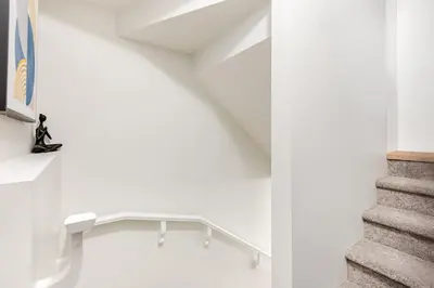 a staircase in a white room with a stair case at Cozy Suite near West Edmonton Mall & River Cree Casino in Edmonton