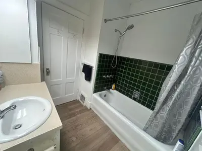 a bathroom with a sink and a bath tub next to a toilet at Vancouver Home - Airport 10 Min, Downtown 15 Min - Free Parking & Fast Wi-Fi in Vancouver