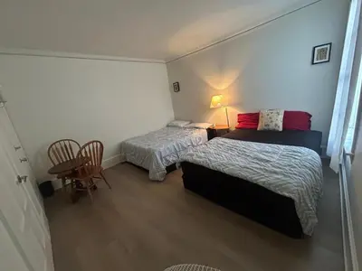a bedroom with two beds and a table and chairs at Vancouver Home - Airport 10 Min, Downtown 15 Min - Free Parking & Fast Wi-Fi in Vancouver