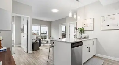 a white kitchen with a counter and a dining room at Mdx in Edmonton