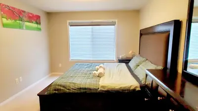 a bedroom with a bed with a teddy bear on it at Entertainment house with 2 king 1 queen 1 sofa bed In-house Theater Attach Garage Near YEG Loved by Guests on Other Plateform in Edmonton