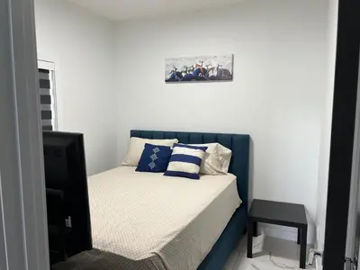 a bed with a blue headboard in a bedroom at Private room with full washroom in Edmonton