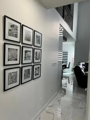 a living room with a bunch of pictures on a wall at Private room with full washroom in Edmonton