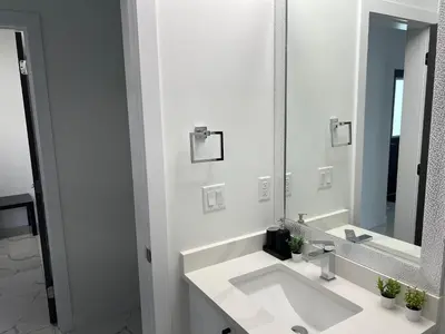 a white bathroom with a sink and a mirror at Private room with full washroom in Edmonton