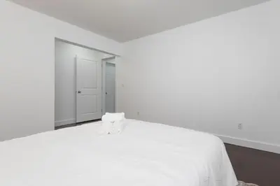 a white bed with two white towels on top of it at Cozy 2B Suite in Great Location Near Trails & Shop in North Vancouver