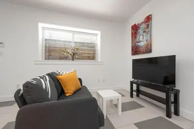 a living room with a couch and a piano at Cozy 2B Suite in Great Location Near Trails & Shop in North Vancouver