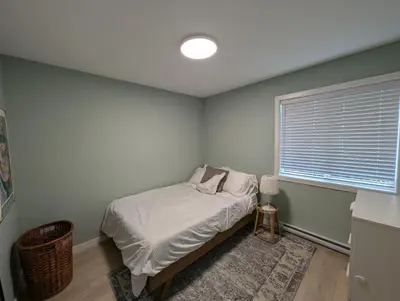a small bedroom with a bed and a window at Colwood Hidden Home in Colwood