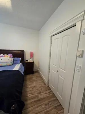 a bedroom with a bed and a white door at Bright Private Room in Echo Valley Home in Victoria