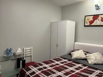 a bedroom with a bed and a white cabinet at Surrey Home - King George Blvd & Rapid Transit - Airport 25 Min - Free Parking & Wi-Fi in Surrey