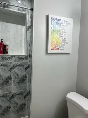 a bathroom with a toilet and a picture on the wall at Surrey Home - King George Blvd & Rapid Transit - Airport 25 Min - Free Parking & Wi-Fi in Surrey